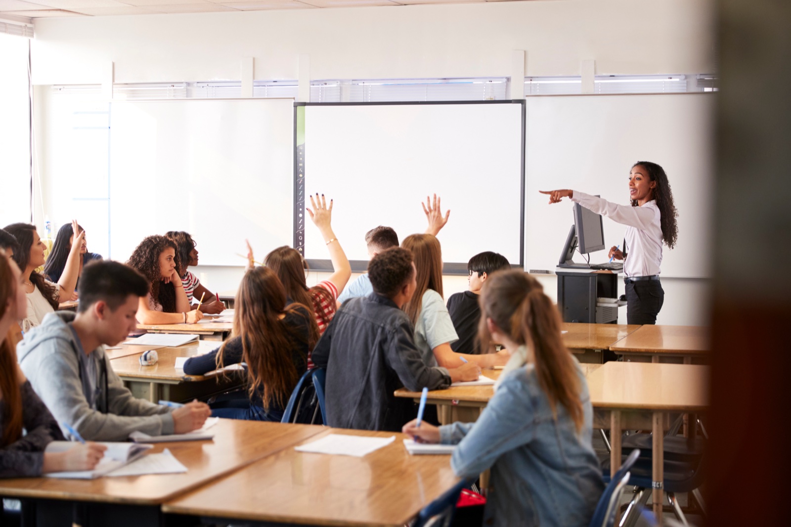 Studenti e docente lavorano insieme su una lavagna interattiva in aula