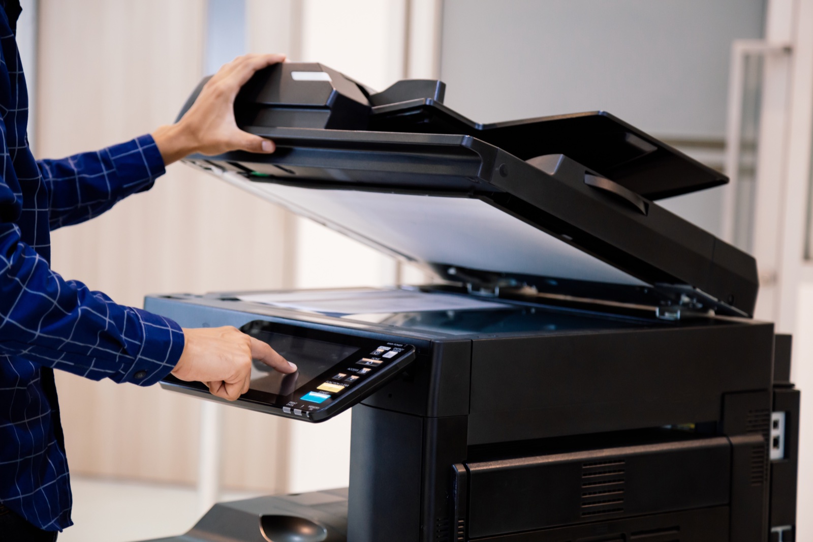 Operatore al pannello di una multifunzione da ufficio: con il noleggio operativo assistenza e toner sono inclusi
