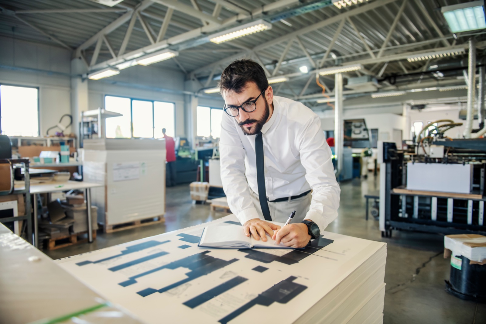 Grafico al lavoro su calcoli e prove di stampa in tipografia